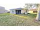 Backyard with a screened-in lanai, lush lawn and mature tree offering shade at 14112 Queenside St, Orlando, FL 32824