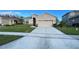 Charming single-story home featuring a manicured lawn and a two-car garage at 14112 Queenside St, Orlando, FL 32824