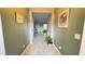 Bright hallway featuring neutral paint, tile floor, and view into the living area at 14112 Queenside St, Orlando, FL 32824