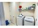 Laundry room with new washer and dryer, storage shelf and tiled floor at 14112 Queenside St, Orlando, FL 32824