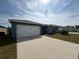 Street view of single-story home featuring a two-car garage and well-maintained lawn at 1629 Ambar Ct, Winter Haven, FL 33881