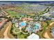 Soak in the splendor of this community's aerial view, showcasing a golf course, pools, and a picturesque neighborhood at 1646 Moon Valley Dr, Davenport, FL 33896