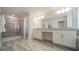 Modern bathroom with dual sinks, a glass-enclosed shower, and sleek tile flooring at 1646 Moon Valley Dr, Davenport, FL 33896