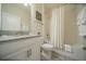 Full bathroom showcasing a shower-tub, white vanity with granite top, and stylish gray wood floors at 1646 Moon Valley Dr, Davenport, FL 33896