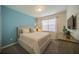 Bright bedroom featuring a queen-size bed, soft carpet and a serene turquoise accent wall at 1646 Moon Valley Dr, Davenport, FL 33896