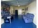Finished garage with air hockey table, Marvel-themed mural, and comfortable seating area at 1646 Moon Valley Dr, Davenport, FL 33896