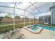 Relaxing screened-in pool area featuring a spa, pool, and poolside lounge chairs at 1646 Moon Valley Dr, Davenport, FL 33896