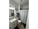 Bright bathroom featuring granite countertop, vanity, and shower with decorative starfish curtain at 1664 Redfin Dr, Kissimmee, FL 34759