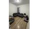 Small bedroom with neutral walls, light hardwood floors, and a dark gray sofa bed at 1664 Redfin Dr, Kissimmee, FL 34759