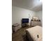 Bedroom features a TV, dresser, nightstand, and wood-look floors at 1664 Redfin Dr, Kissimmee, FL 34759