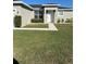 Well-maintained front yard featuring a green lawn, walkway leading to the front door, and manicured bushes at 1664 Redfin Dr, Kissimmee, FL 34759