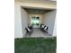 Covered patio area with dark furniture, sliding glass door, and a view of the green backyard at 1664 Redfin Dr, Kissimmee, FL 34759