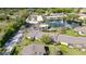 Aerial view featuring a well-maintained community with mature trees, pool, pond, and ample parking at 1695 Lee Rd # E103, Winter Park, FL 32789