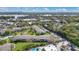 Scenic aerial view of condos with a pond, green spaces, parking, and community pool on a sunny day at 1695 Lee Rd # E103, Winter Park, FL 32789