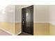 A dark-colored front door with a handle and a unit number sign, set against neutral-colored walls at 1695 Lee Rd # E103, Winter Park, FL 32789