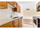 Kitchen featuring wooden cabinets, mosaic tile backsplash and stainless steel appliances at 1695 Lee Rd # E103, Winter Park, FL 32789