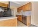 Compact kitchen with wooden cabinetry, white countertops, and updated appliances at 1695 Lee Rd # E103, Winter Park, FL 32789