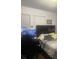 This bedroom features two windows, gaming setup, and a bed with striped linens at 1749 Fulfillment Dr, Kissimmee, FL 34744