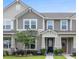Charming townhouse featuring a covered porch, well-maintained lawn, and neutral-toned siding at 1749 Fulfillment Dr, Kissimmee, FL 34744