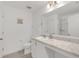 Well-lit bathroom featuring a marble countertop, sink, toilet, and a framed mirror at 1877 River Crest Ave, St Cloud, FL 34771
