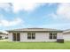 Back exterior view of home with solar panels and a well-maintained lawn at 1877 River Crest Ave, St Cloud, FL 34771
