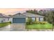 Charming single-story home featuring a well-maintained lawn, a two-car garage, and attractive landscaping at 1877 River Crest Ave, St Cloud, FL 34771