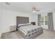Cozy main bedroom with a tufted headboard, side tables, a ceiling fan, and a bright window at 1877 River Crest Ave, St Cloud, FL 34771