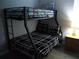 This cozy bedroom features bunk beds, dark wood floors, and warm natural lighting at 217 Sand Ridge Dr, Davenport, FL 33896