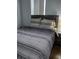 This bedroom features neutral walls, light wood floors, and a gray striped bedding at 217 Sand Ridge Dr, Davenport, FL 33896