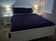 This bright bedroom offers warm lighting from beside lamps, a queen bed, and wood flooring at 217 Sand Ridge Dr, Davenport, FL 33896
