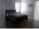This bedroom features neutral walls, tile floors, a dark wood bed, and natural lighting at 217 Sand Ridge Dr, Davenport, FL 33896