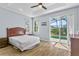 Bedroom with wood-look floors, windows, and access to the pool via sliding glass door at 217 Sand Ridge Dr, Davenport, FL 33896