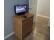 This bedroom features a wooden nightstand, TV, dark wood floors, and neutral walls at 217 Sand Ridge Dr, Davenport, FL 33896