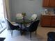 This dining room features a glass table, four cushioned chairs, and natural light at 217 Sand Ridge Dr, Davenport, FL 33896