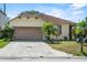 Charming single-Gathering home with a tan exterior, attached garage and a well-manicured front yard at 217 Sand Ridge Dr, Davenport, FL 33896