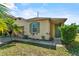 Lovely one-story home with green trim, beige siding, green door, and green tropical landscaping at 217 Sand Ridge Dr, Davenport, FL 33896