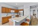 Well-lit kitchen featuring wooden cabinetry, stainless steel appliances, and a breakfast bar at 217 Sand Ridge Dr, Davenport, FL 33896