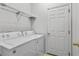 Functional laundry room includes washer, dryer, storage shelf, and access door at 217 Sand Ridge Dr, Davenport, FL 33896