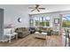 Bright living room with wood-style tile, comfortable seating, and large windows overlooking the backyard at 217 Sand Ridge Dr, Davenport, FL 33896