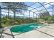 The screened-in pool area features an inviting pool and spa and a relaxing outdoor space with a pleasant view at 217 Sand Ridge Dr, Davenport, FL 33896