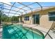 The backyard pool features a screened enclosure with sliding glass door access to the home at 217 Sand Ridge Dr, Davenport, FL 33896