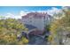 A ground level view of the property entrance and surrounding trees with blue skies at 3000 Maingate Ln # 205, Kissimmee, FL 34747