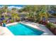 A beautiful turquoise swimming pool area is surrounded by greenery and palm trees with lounge chairs at 3000 Maingate Ln # 205, Kissimmee, FL 34747