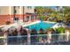 An outdoor swimming pool surrounded by a white fence with lush landscaping at this gorgeous hotel resort at 3000 Maingate Ln # 205, Kissimmee, FL 34747