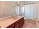 Bathroom featuring a white shower curtain, light cabinets and tile floors at 318 Rock Springs Dr, Poinciana, FL 34759