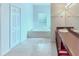 Bright bathroom featuring a soaking tub, tile flooring, white cabinets and double sinks at 318 Rock Springs Dr, Poinciana, FL 34759