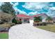 Charming single-story home featuring a well-manicured lawn, paver driveway, and inviting landscaping at 318 Rock Springs Dr, Poinciana, FL 34759