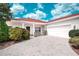 Charming single-story home with a two-car garage, red roof and a well-manicured lawn, all under a sunny, partly cloudy sky at 318 Rock Springs Dr, Poinciana, FL 34759