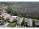 A scenic aerial view shows this property with lush landscaping, a wooded area, and neighboring houses at 400 Indian Wells Ave, Poinciana, FL 34759