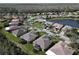 A scenic aerial view shows this property with lush landscaping, a pond, and neighboring houses at 400 Indian Wells Ave, Poinciana, FL 34759